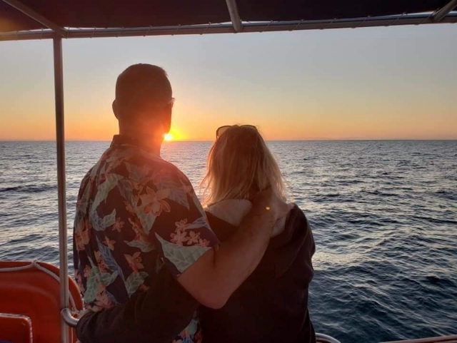 Pareja navegando al atardecer