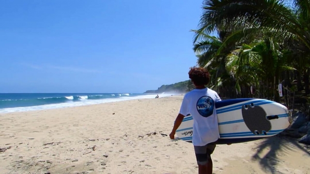 Marcher sur la plage avec une planche de surf 