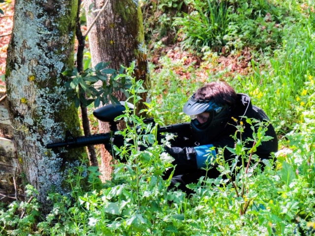 Jugador de gotcha entre los matorrales