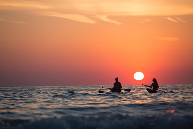 Pareja montada en la tabla de surf