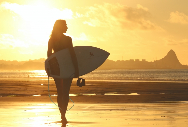 Chica atardecer con tabla de surf
