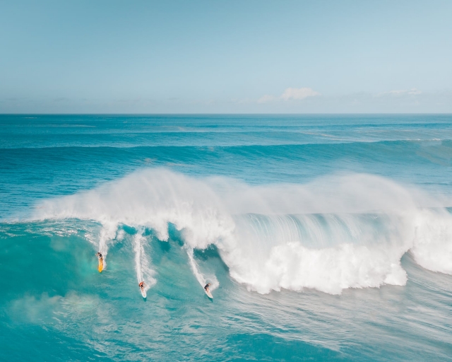 tres surfistas en el mar