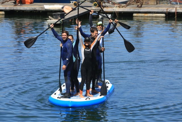 saludando sobre tabla de paddle board