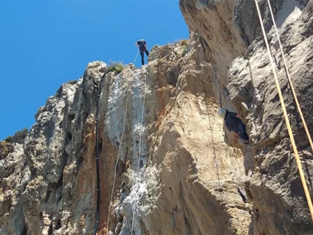 Preparandose para bajar por la pared rapelando