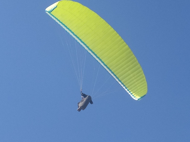 Un parapenle sobre un cielo azul 