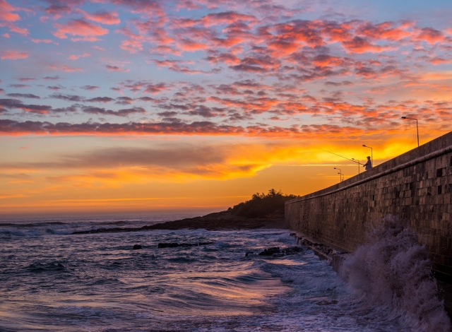 Precioso atardecer con un pescador aventando la caña al mar