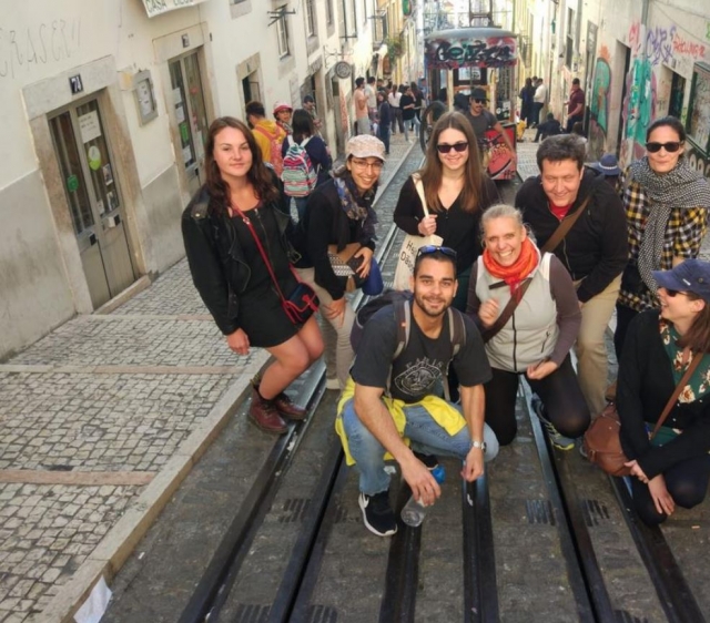 Posando en una calle en cuesta con el tranvía al fondo