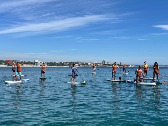 Un nutrido grupo de usuarios metidos en el agua haciendo paddle board
