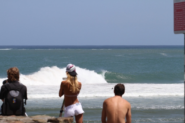 Bañistas observan a los surfistas