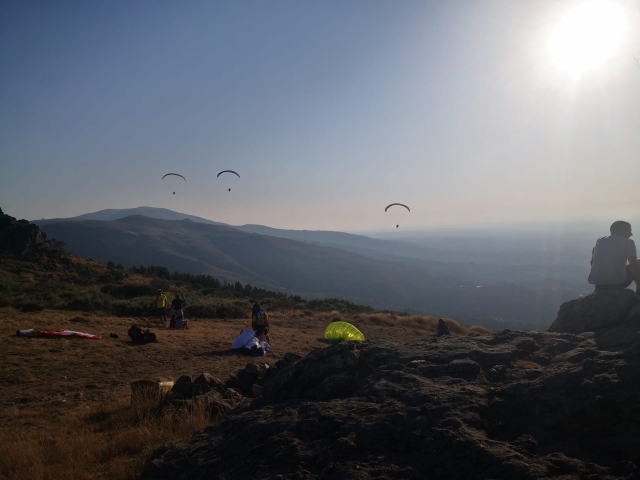 Varios parapentes en la lejanía desde la loma de una cerro