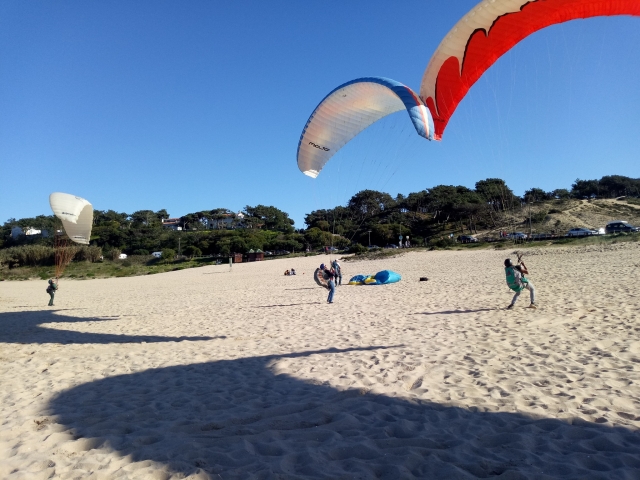 La sombra de los parapentes en la arena