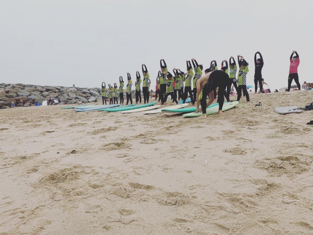 Haciendo ejercicios de estiramientos en la playa con los pequeños