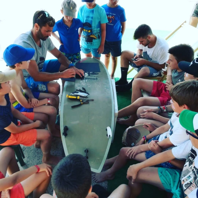 Instructor acondicionando una tabla rodeado de niños