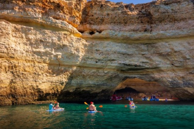 Varios kayaks fondeando un acantilado