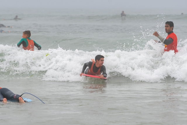 Un chico tomando la inercia de una ola totalmenle tumbado
