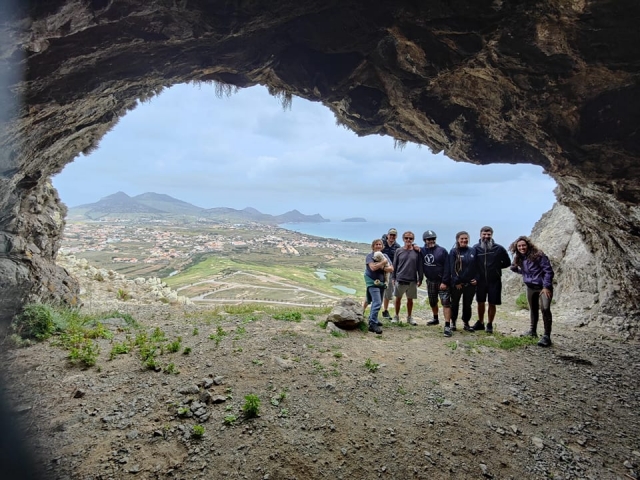 Un grupo de amigos a la entrada de un arco de piedra