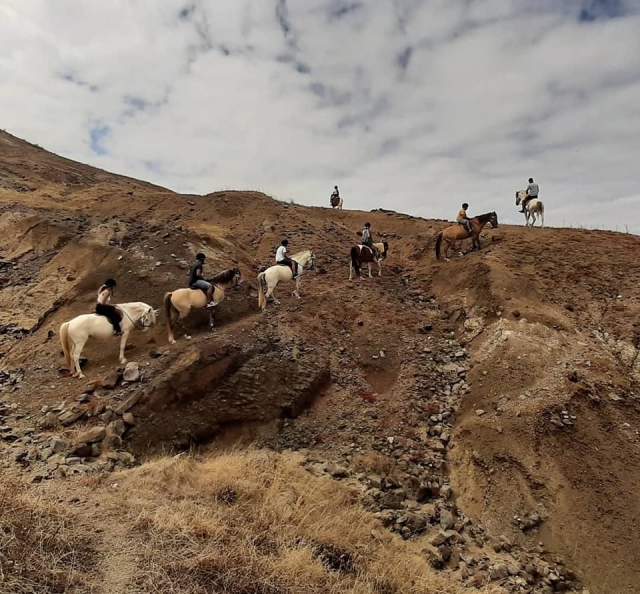 Ascendiendo a lomos de un caballo por un terreno árido