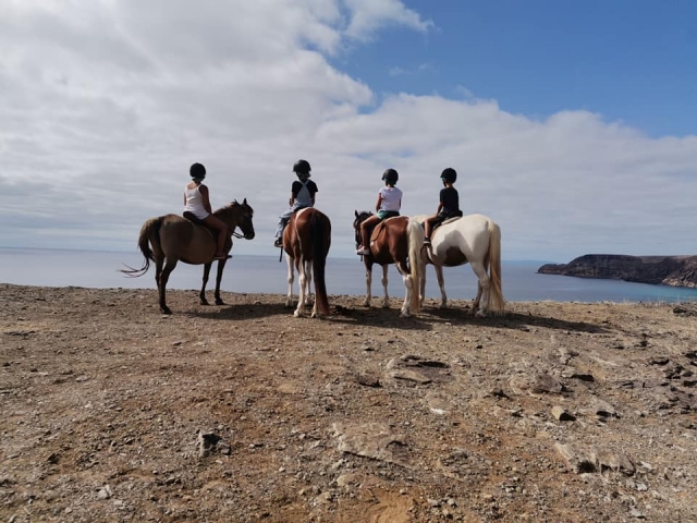 Un grupo de cuatro amigas contemplando el horizonle de nubes caballo 