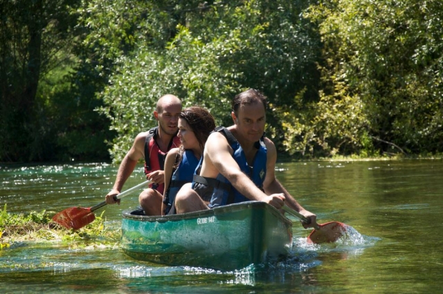 Una canoa con tres componentes navegando por el agua