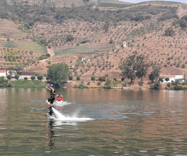 Un usuario haciendo malabares aéreos con la jet ski al fondo