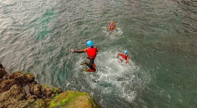 Chica saltando de una roca