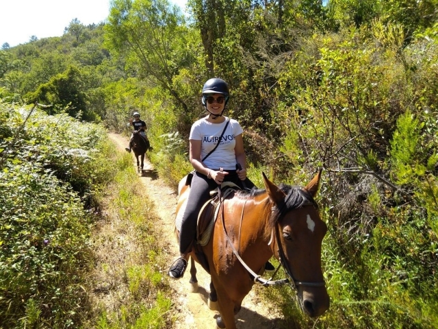 Mujer cabalgando por el campo