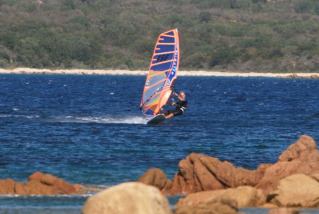  Hombre deslizándose sobre el agua con un Wind Surf 