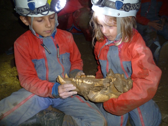  Niño con calavera de oso de las cavernas 