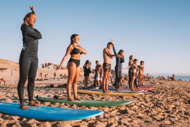  Lección de surf estirándose en la playa 