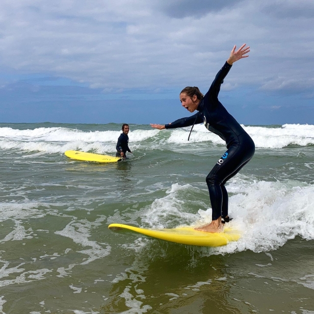 Chica surfeando a la orilla del agua 
