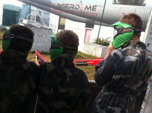  Tres niños de espaldas equipados para jugar gotcha 