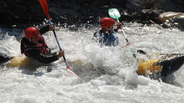  Dos personas remando mientras hacen rafting 