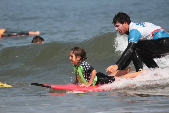  Instructor y niña surfeando 
