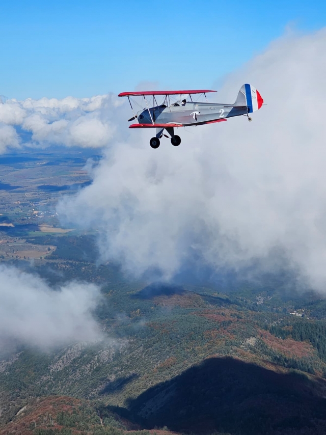  Sobrevolando las montañas a bordo de un avión biplaza retro 