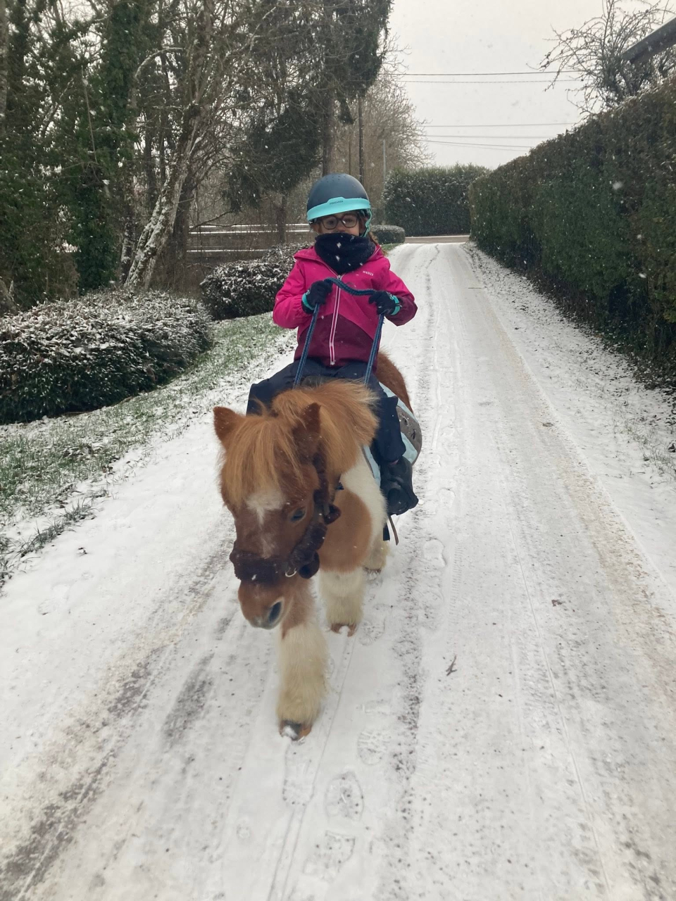  Un niño en un pony en la nieve 